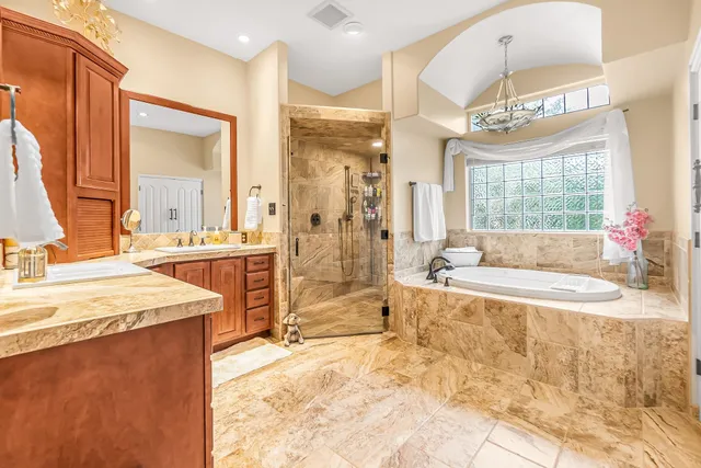 a spacious bathroom with a tub sink shower and mirror