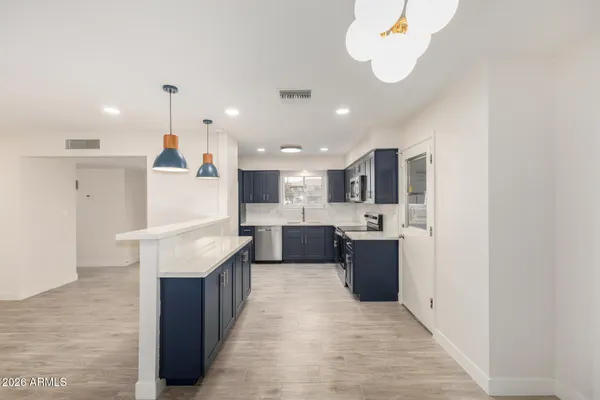 a large kitchen with a large counter top appliances and cabinets