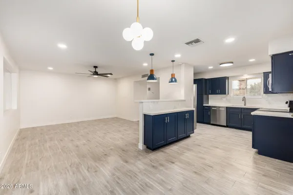 a large kitchen with stainless steel appliances kitchen island a large counter top and a wooden floors