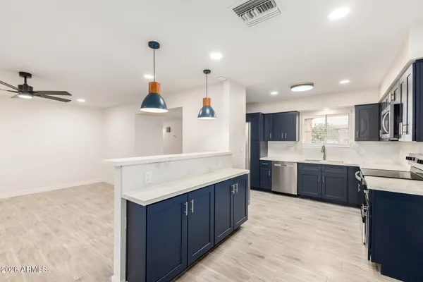 a kitchen with kitchen island sink stove and refrigerator
