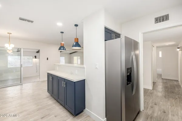 a kitchen with stainless steel appliances kitchen island granite countertop a refrigerator and a sink