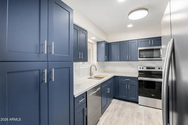 a kitchen with stainless steel appliances granite countertop a sink stove and refrigerator
