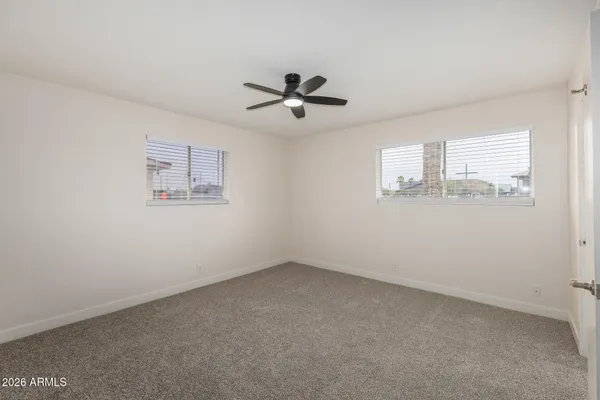 an empty room with a window and a ceiling fan