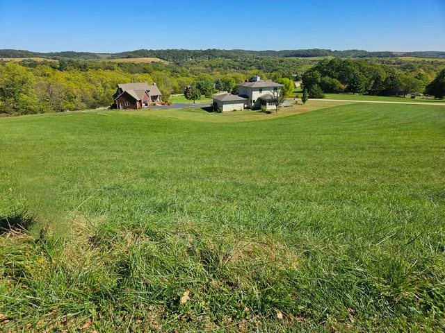 a view of a green field with lawn chairs