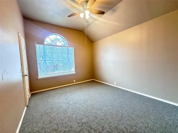 a view of an empty room with a chandelier fan