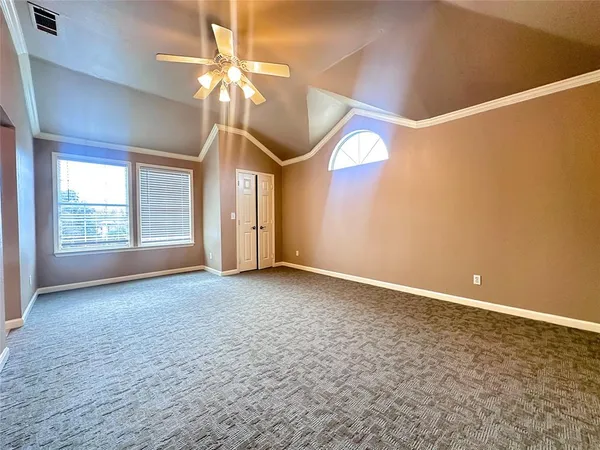 a view of an empty room with a chandelier fan