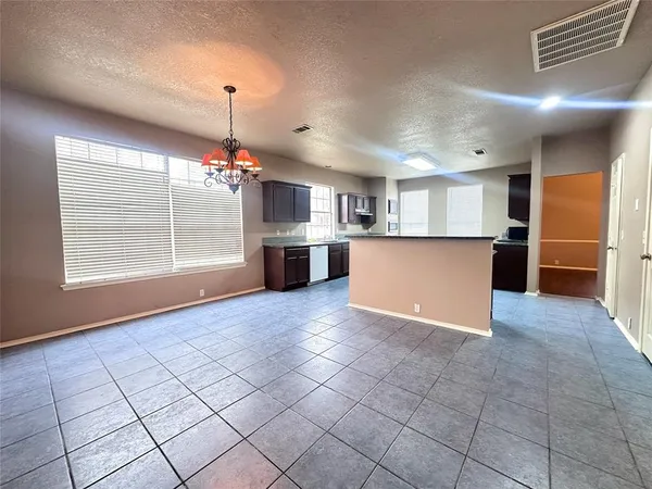 a large kitchen with stainless steel appliances kitchen island granite countertop a large counter top a stove and a sink