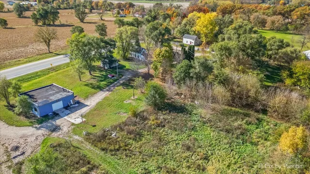 an aerial view of residential house with outdoor space and trees all around