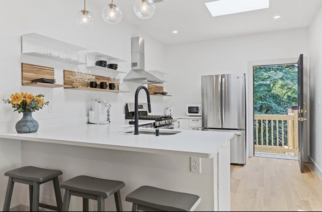 43 Wordsworth Street, Unit 1 Boston, MA 02128 - Photo 3 of 19 a kitchen with stainless steel appliances a sink a table and chairs