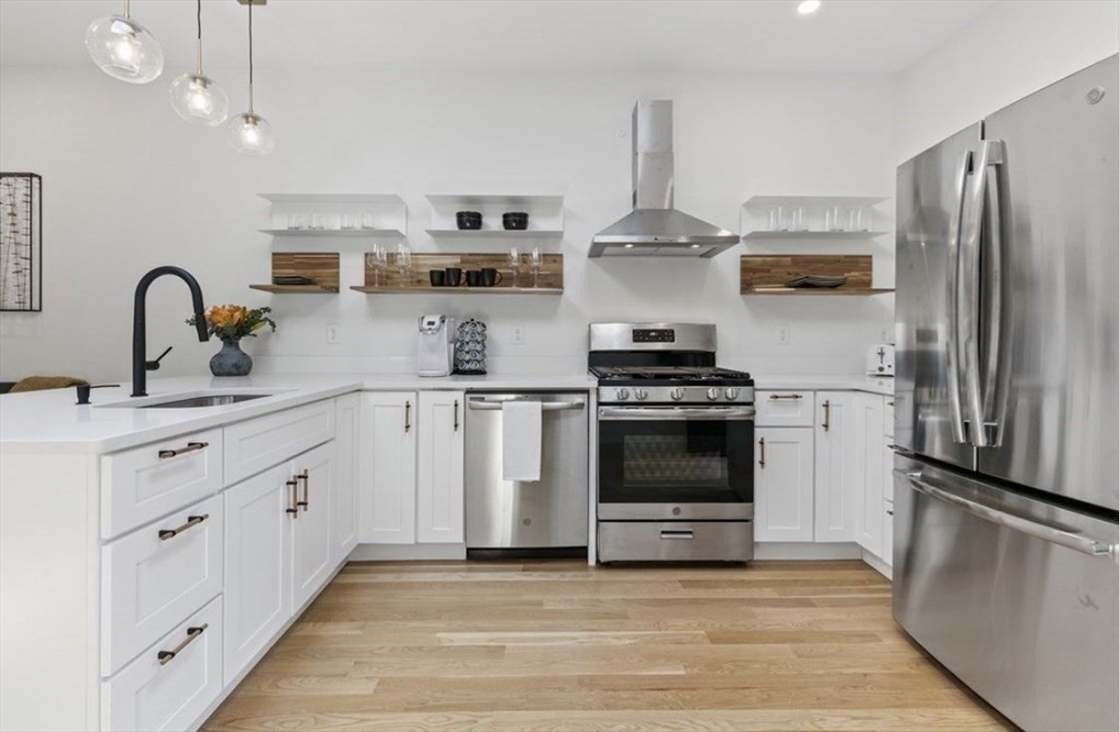 43 Wordsworth Street, Unit 1 Boston, MA 02128 - Photo 5 of 19 a kitchen with white cabinets and stainless steel appliances