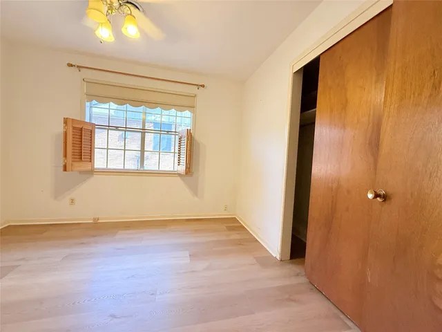 an empty room with window and wooden floor