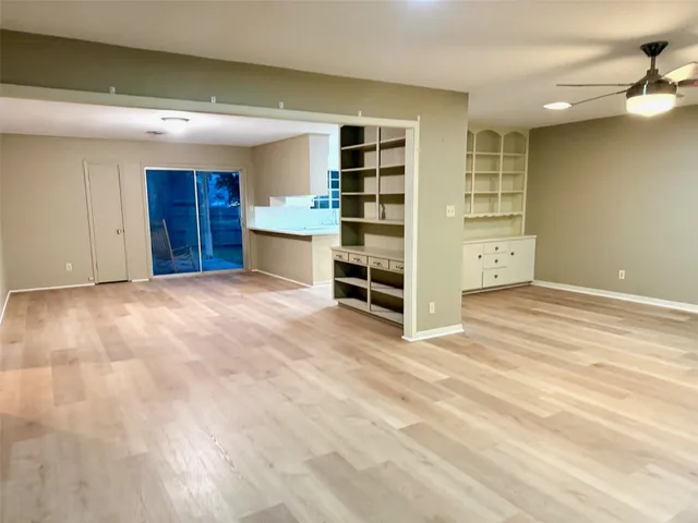 a view of an empty room with cabinet and stairs