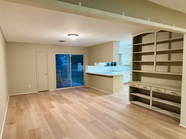 a view of an empty room with cabinet and a window