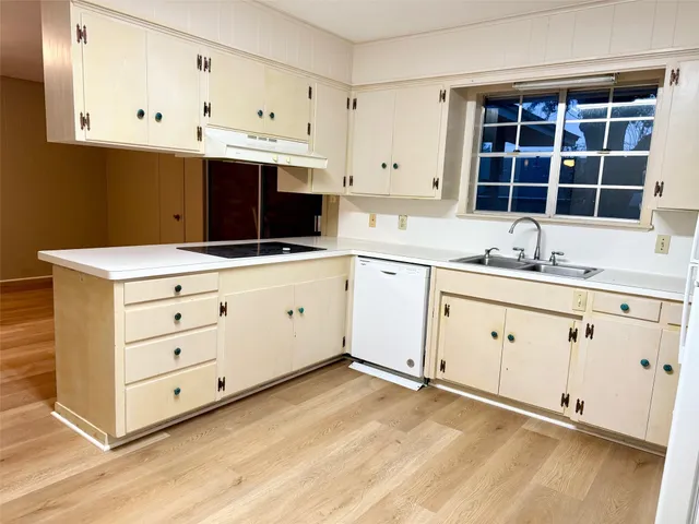 a kitchen with granite countertop white cabinets stainless steel appliances a sink and a window