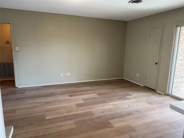a view of an empty room and wooden floor