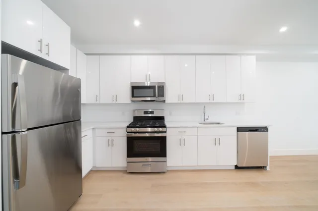 a kitchen with stainless steel appliances a refrigerator a stove a microwave and cabinets