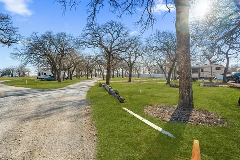 a view of a house with a big yard and large trees