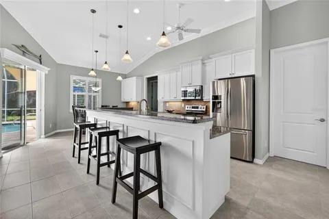 a kitchen with kitchen island a refrigerator a stove a dining table and chairs