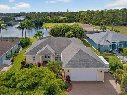 an aerial view of a house with a garden and lake view