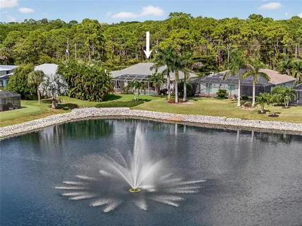 an aerial view of a house with a yard and lake view