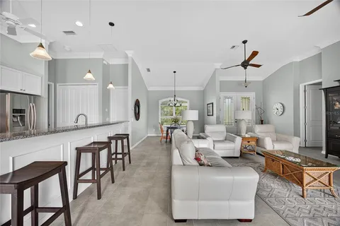 a living room with furniture kitchen view and a large mirror