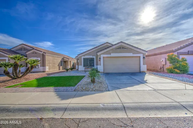 a front view of a house with garage and plants