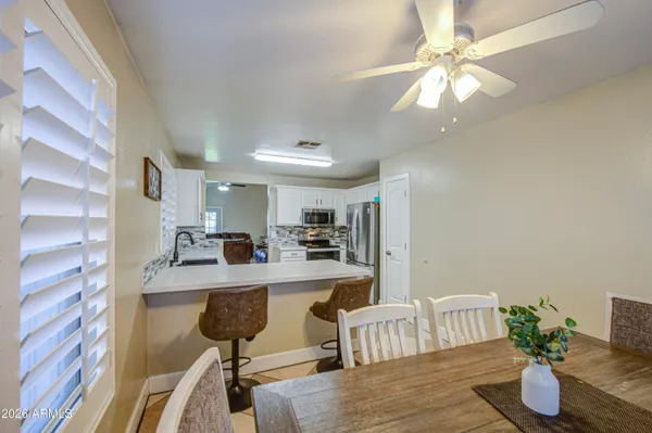 a view of a dining room and livingroom with furniture wooden floor a chandelier