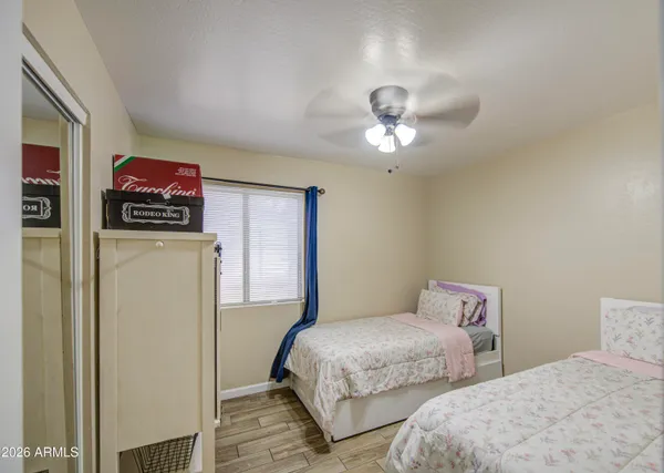 a bedroom with two bed and a chandelier