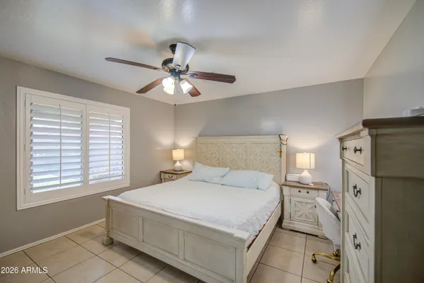 a bedroom with a bed and a refrigerator