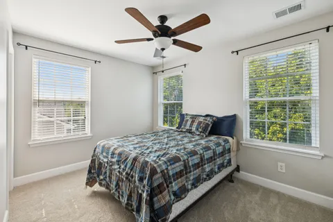 a bed sitting in a bedroom next to a window