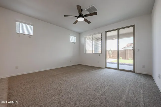 a view of an empty room and kitchen view