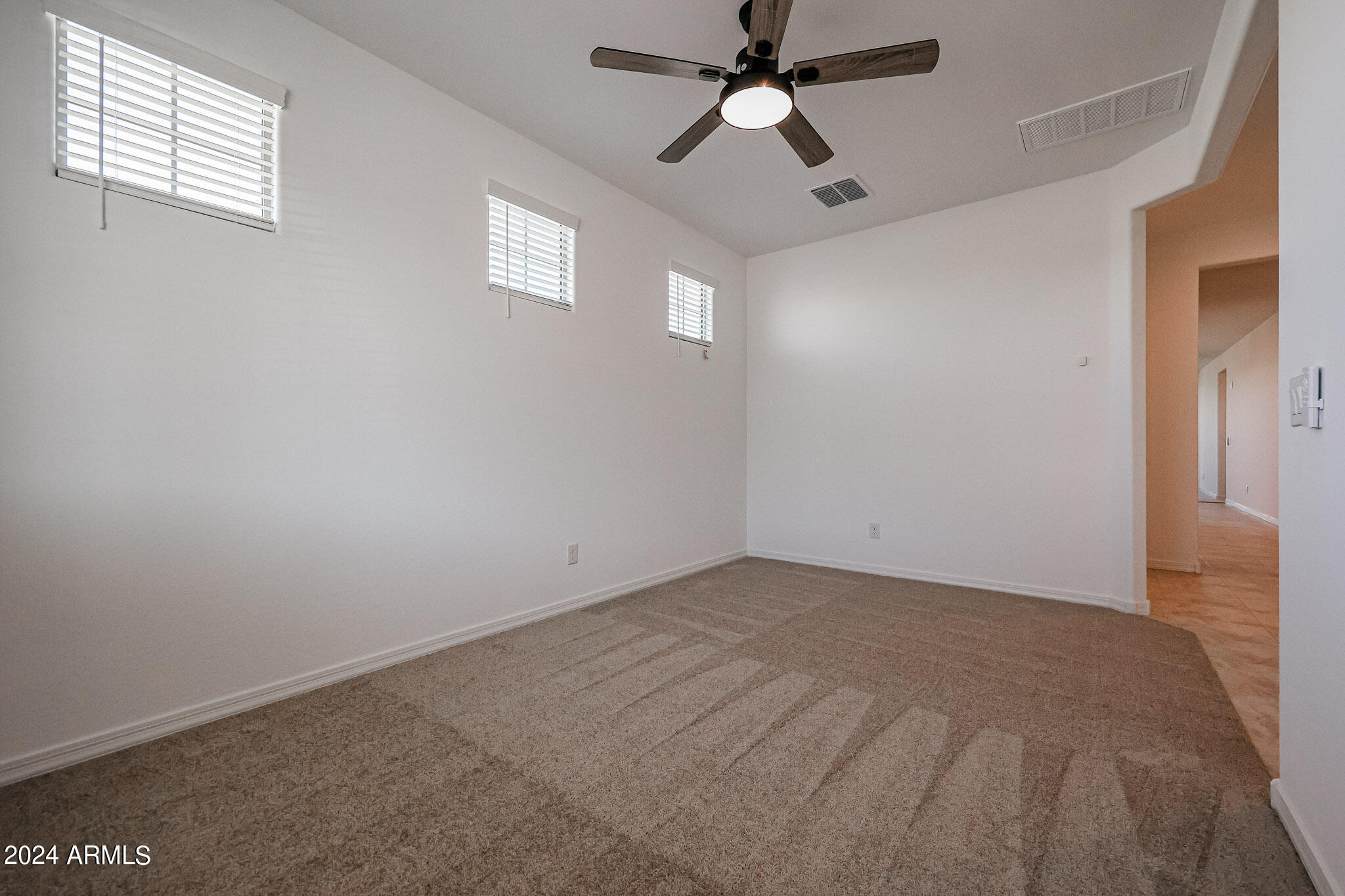 8907 West Colter Street Glendale, AZ 85305 - Photo 16 of 44 an empty room with windows and fan