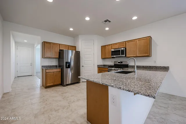 a kitchen with stainless steel appliances granite countertop a sink refrigerator and microwave