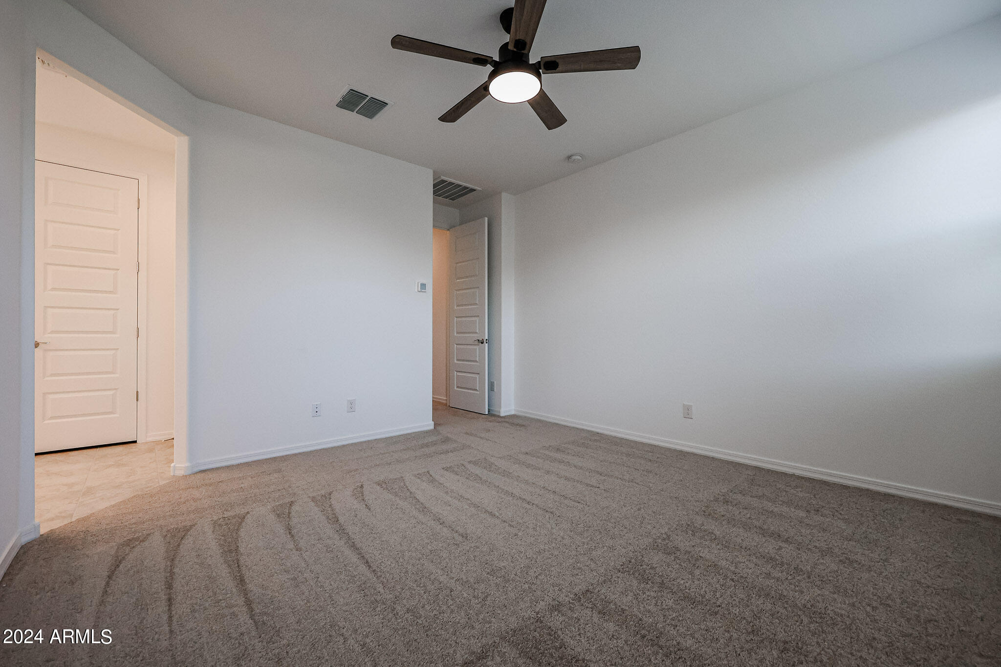 8907 West Colter Street Glendale, AZ 85305 - Photo 21 of 44 en empty room with ceiling fan and window