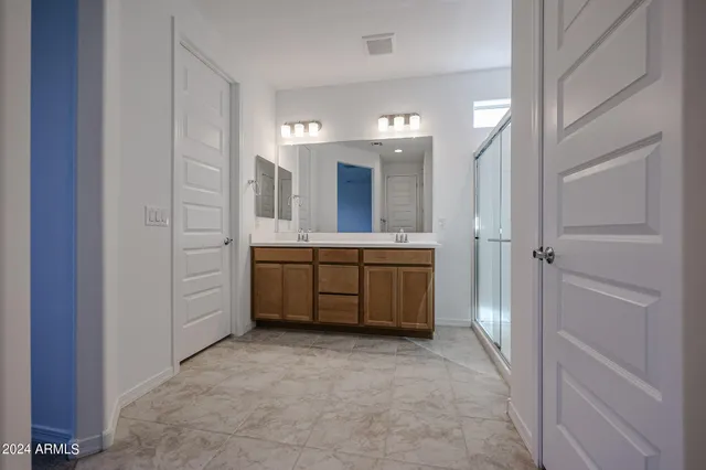 a bathroom with a double vanity sink mirror and bathtub