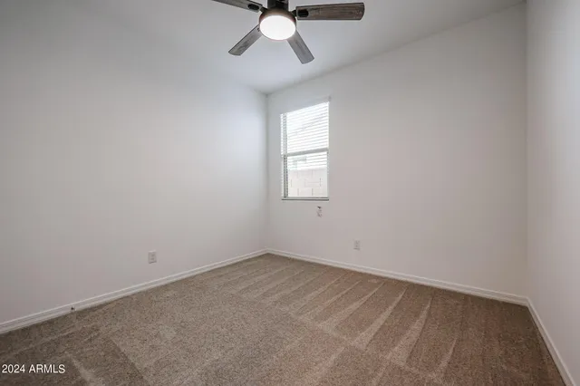 an empty room with closet and a chandelier fan