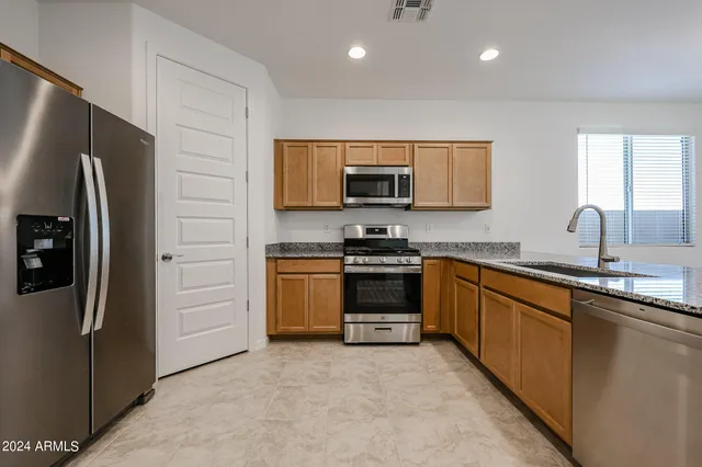 a kitchen with stainless steel appliances a refrigerator sink and microwave