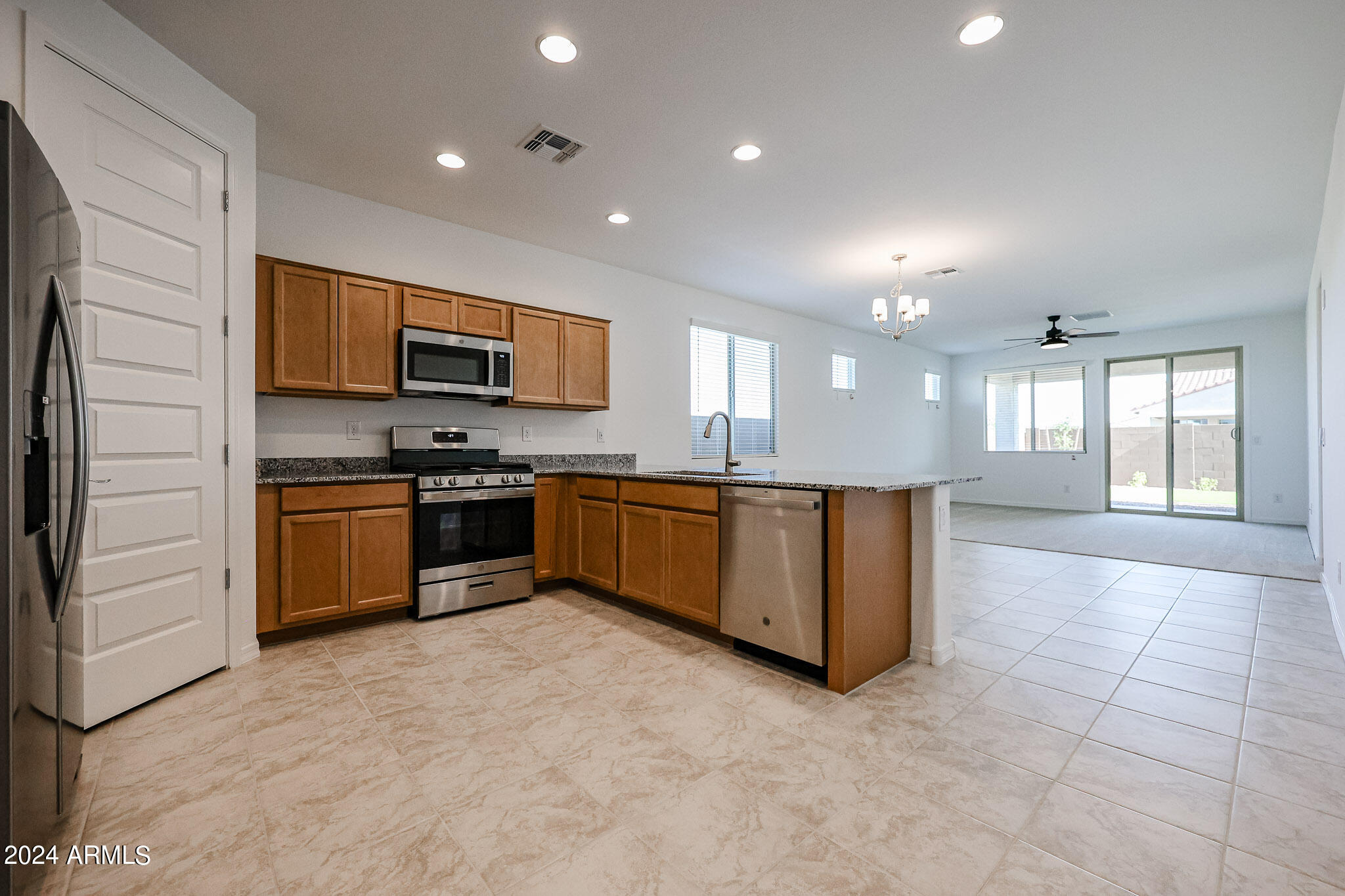 8907 West Colter Street Glendale, AZ 85305 - Photo 44 of 44 a large kitchen with stainless steel appliances granite countertop a stove a sink and a refrigerator
