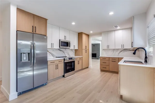 a kitchen with a refrigerator sink and stainless steel appliances