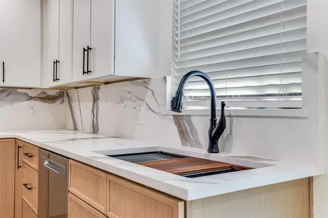 a kitchen with granite countertop white cabinets and wooden floor
