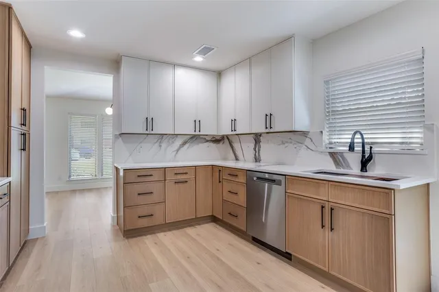 a kitchen with granite countertop white cabinets and sink