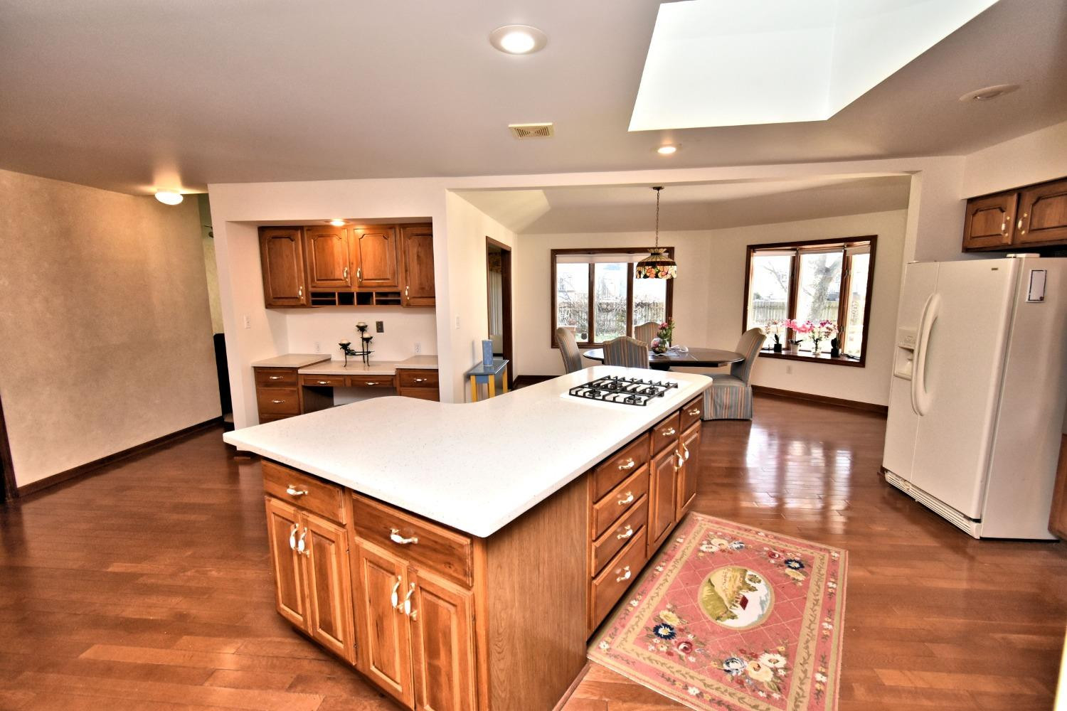 8408 Castle Drive Munster, IN 46321 - Photo 13 of 28 a large kitchen with stainless steel appliances a stove a sink dishwasher and a refrigerator with wooden floor