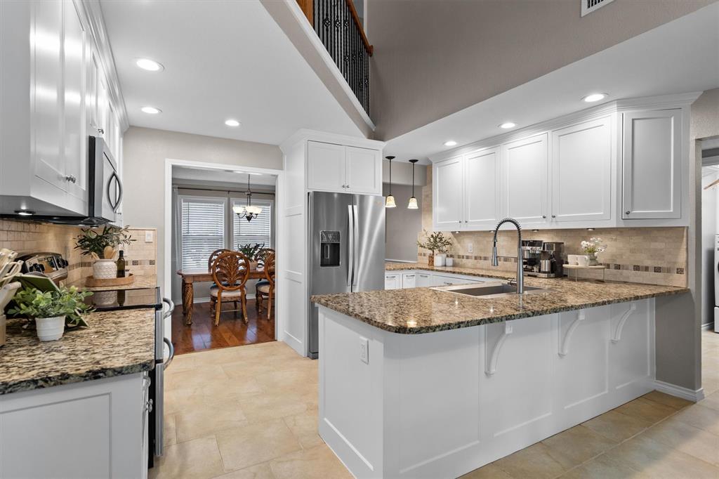 410 Simmons Road Double Oak, TX 75077 - Photo 13 of 40 Chef's kitchen with granite countertops, rich cabinetry, and generous prep space.
