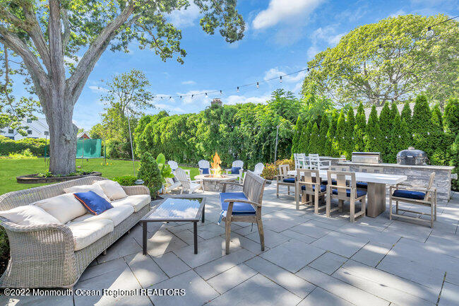 2107 3rd Avenue Spring Lake, NJ 07762 - Photo 37 of 40 a view of a patio with dining table and chairs with a large tree