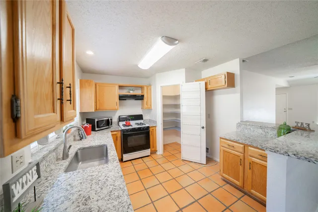a kitchen with stainless steel appliances granite countertop a refrigerator and a sink