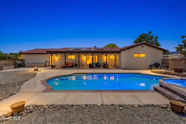 a view of a house with pool and chairs
