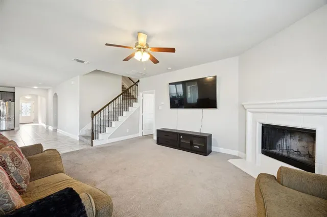 a living room with furniture a flat screen tv and a fireplace