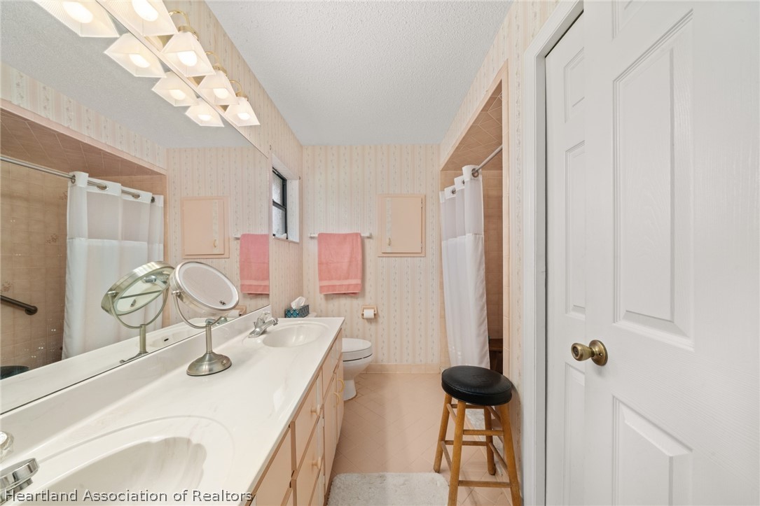 5802 Golden Road Sebring, FL 33875 - Photo 18 of 37 a bathroom with a sink vanity granite and toilet
