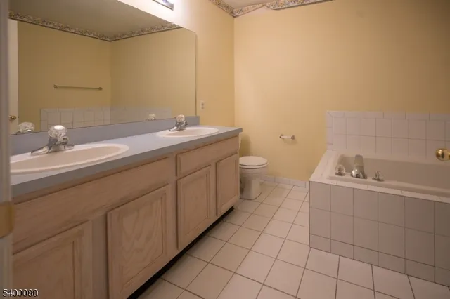a spacious bathroom with a double vanity sink toilet and a mirror