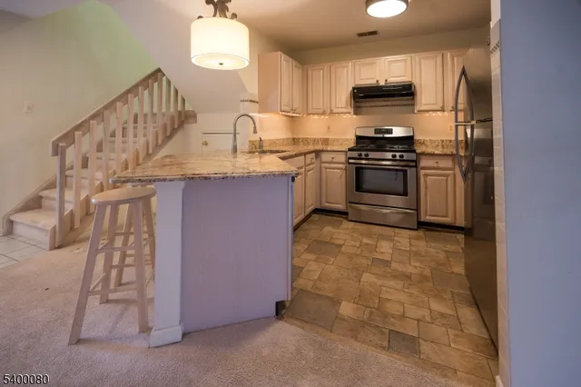 a kitchen with stainless steel appliances granite countertop a stove a sink and a refrigerator